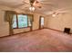Spacious living room featuring carpeting, large windows, and unique ceiling fans at 5760 Brenda Sw Dr, Mableton, GA 30126