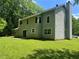 View of the backyard, featuring a large grassy area and mature trees at 6848 Timberhead Way, Lithonia, GA 30058