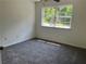 Bright, carpeted bedroom featuring a ceiling fan and large window at 6848 Timberhead Way, Lithonia, GA 30058