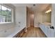 Bright bathroom with a large window, soaking tub, and vanity with white cabinets at 8256 Milam Loop, Fairburn, GA 30213