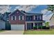 Charming two-story brick home with attached garage, landscaped yard, and covered front porch at 8256 Milam Loop, Fairburn, GA 30213