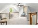 Well-lit attic space with neutral carpeting, chair railing, and dormer windows at 8901 Watkins Mill Rd, Winston, GA 30187