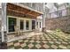 Stone patio with checkered grass design and rocking chairs, offering a serene outdoor retreat at 8901 Watkins Mill Rd, Winston, GA 30187