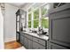 Modern bar area with dark cabinetry, granite countertops, and a built-in sink at 8901 Watkins Mill Rd, Winston, GA 30187