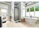 Bright bathroom with tub, walk-in shower, tile floors, and access to the backyard at 8901 Watkins Mill Rd, Winston, GA 30187
