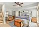 Neutral bedroom space with stairs, ceiling fan and a cozy armchair near a side table at 8901 Watkins Mill Rd, Winston, GA 30187