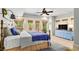 Sunny bedroom featuring a blue accent wall, ceiling fan, and doors to the outside at 8901 Watkins Mill Rd, Winston, GA 30187