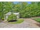 Detached garage with a basketball hoop on the driveway in a wooded area at 8901 Watkins Mill Rd, Winston, GA 30187