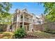 Exterior view of the house with a stone patio, lush landscaping, and a second-story deck at 8901 Watkins Mill Rd, Winston, GA 30187