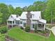 Stunning two-story home with a metal roof, stone chimney, covered porches, and manicured lawn and landscaping at 8901 Watkins Mill Rd, Winston, GA 30187