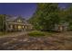 Inviting covered porch with comfortable seating, a ceiling fan, and stone steps amidst lush landscaping at 8901 Watkins Mill Rd, Winston, GA 30187