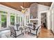 Beautiful sunroom with stone fireplace, wood ceiling, many windows with a view of the forest at 8901 Watkins Mill Rd, Winston, GA 30187