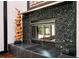 Close-up of a stone-encased fireplace with a modern glass enclosure at 1216 E Rock Springs Ne Rd, Atlanta, GA 30306
