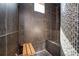 Sleek shower showcasing dark tile, a wooden seat, and mosaic accents, providing a modern and relaxing ambiance at 1216 E Rock Springs Ne Rd, Atlanta, GA 30306