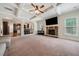 Spacious living room featuring coffered ceilings, stone fireplace, and open layout to kitchen at 1314 Bentley Estates Dr, Dacula, GA 30019