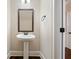 Elegant powder room features a pedestal sink, dark wood trim, and hardwood floors at 1314 Bentley Estates Dr, Dacula, GA 30019