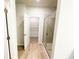 Bathroom with glass shower and view into walk-in closet with wood-look floors at 5096 Cumberland Ct, Villa Rica, GA 30180