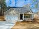 Charming single-story home with a two-car garage, gray siding, and landscaped front yard at 5096 Cumberland Ct, Villa Rica, GA 30180