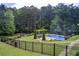 Fenced backyard featuring a sparkling pool, patio, and lush landscaping, creating a private oasis at 608 Red Leaf Way, Canton, GA 30114