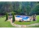 Aerial view of backyard featuring pool, surrounding trees, and stone walking path at 608 Red Leaf Way, Canton, GA 30114