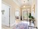 Inviting foyer features decorative glass front door, neutral walls, tray ceiling, and wood-look floors at 608 Red Leaf Way, Canton, GA 30114