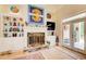 Bright living room featuring a stone fireplace, custom built-ins, and access to the outdoor living space at 608 Red Leaf Way, Canton, GA 30114