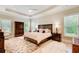 Spacious bedroom features tray ceilings, a ceiling fan, hardwood floors, and large windows at 608 Red Leaf Way, Canton, GA 30114