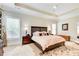 Spacious main bedroom with tray ceilings, a ceiling fan, hardwood floors, and a large window at 608 Red Leaf Way, Canton, GA 30114