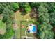 Aerial view of backyard pool and deck surrounded by a well-manicured lawn and mature trees at 608 Red Leaf Way, Canton, GA 30114