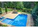 L-shaped swimming pool with a dining set and view of a peaceful treed area at 608 Red Leaf Way, Canton, GA 30114
