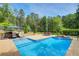 Sparkling swimming pool with an umbrella, lounge chairs, and patio table in a private backyard at 608 Red Leaf Way, Canton, GA 30114