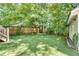 Artificial grass lawn in backyard surrounded by lush landscaping and privacy fence with steps on left at 1157 Alta Ne Ave, Atlanta, GA 30307