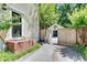 View down the driveway towards a detached garage, next to the house with brick steps and a black front door at 1157 Alta Ne Ave, Atlanta, GA 30307