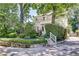 Charming two-story home exterior with landscaped front yard and stone retaining wall and driveway at 1157 Alta Ne Ave, Atlanta, GA 30307