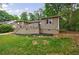 Home featuring a backyard with a raised patio, mature trees, and lawn at 1304 Anchor Sw Ter, Atlanta, GA 30311