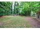 Lush, landscaped backyard featuring mature trees, a garden, and green grass at 1304 Anchor Sw Ter, Atlanta, GA 30311