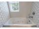 Close-up of a bathtub with hexagon tile surround and modern fixtures at 1304 Anchor Sw Ter, Atlanta, GA 30311