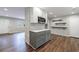 Open kitchen features gray cabinets, wood flooring, painted brick accent wall and stainless steel appliances at 1304 Anchor Sw Ter, Atlanta, GA 30311