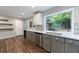 Bright kitchen with stainless appliances, gray cabinets, stylish backsplash and large window viewing the backyard at 1304 Anchor Sw Ter, Atlanta, GA 30311