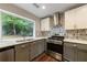 Bright kitchen featuring stainless steel appliances, stylish backsplash, wood floors, and a large window overlooking the yard at 1304 Anchor Sw Ter, Atlanta, GA 30311
