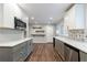 Updated kitchen with gray lower cabinets, white upper cabinets, stainless steel appliances, and modern backsplash at 1304 Anchor Sw Ter, Atlanta, GA 30311