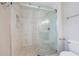 Walk-in shower with white marble tile and a frameless glass door at 1304 Anchor Sw Ter, Atlanta, GA 30311