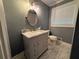 Bathroom with marble countertop vanity, oval mirror, updated lighting, and large window for plenty of natural light at 25 Stonehedge Dr, Buford, GA 30518