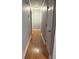 Hallway with hardwood floors, neutral paint, an overhead light, and a view of the open doorway at 25 Stonehedge Dr, Buford, GA 30518