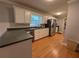 Modern kitchen features stainless steel appliances, white cabinetry, and large countertop with beautiful hardwood floors at 25 Stonehedge Dr, Buford, GA 30518