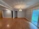 Spacious living room with hardwood floors, neutral paint, decorative chandelier, and sliding glass door leading to patio at 25 Stonehedge Dr, Buford, GA 30518