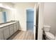 Bathroom featuring double sinks, granite countertops, toilet and bedroom entrance at 5295 Greenway Dr, Villa Rica, GA 30180