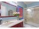 Well-lit bathroom features a stylish vanity, framed mirror, vibrant artwork, and a shower with glass doors at 690 Mcgill Ne Pl, Atlanta, GA 30312