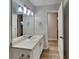 Bright bathroom with bright lighting, vanity, mirror, and doorway leading to another room at 943 Colvin Dr, Locust Grove, GA 30248
