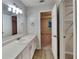 Bathroom with bright lighting, vanity, mirror, and doorway leading to the bedroom at 943 Colvin Dr, Locust Grove, GA 30248